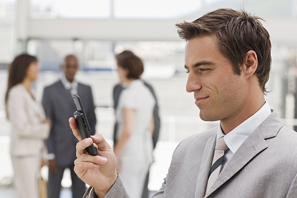 Closeup of young businessman text messaging